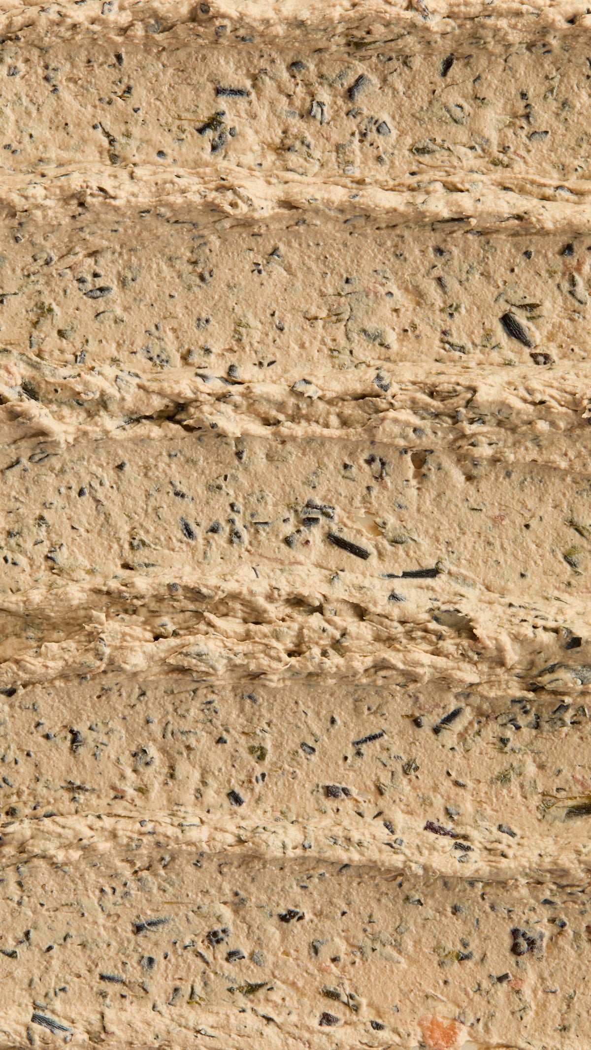 A super close-up image of the creamy, textured Mineralise Me face mask product, focusing on the thick consistency of the flecks of finely blended seaweed.